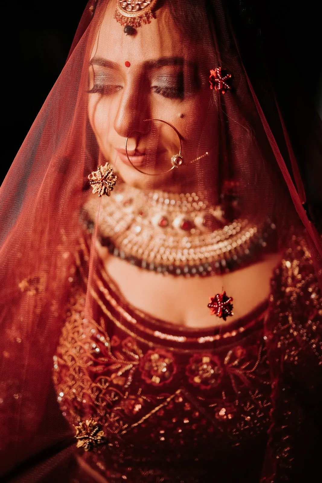 Bridal portrait beneath a red veil